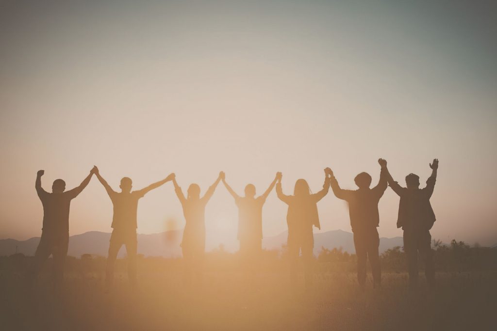 People holding hands looking at sunrise